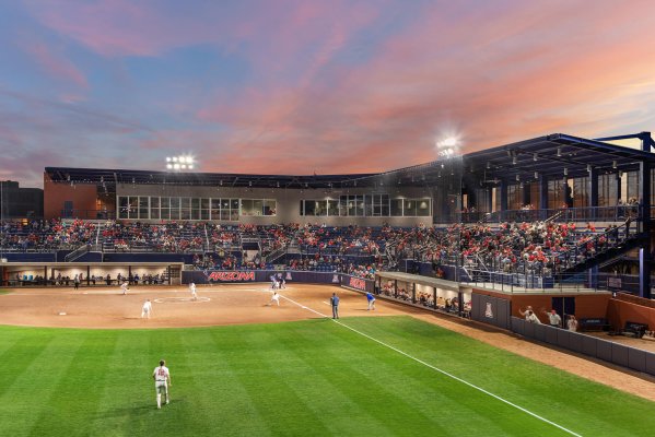 Baseball players playing a game in front of a large crowed in a stadium designed by the architectural design team at Swaim Associates
